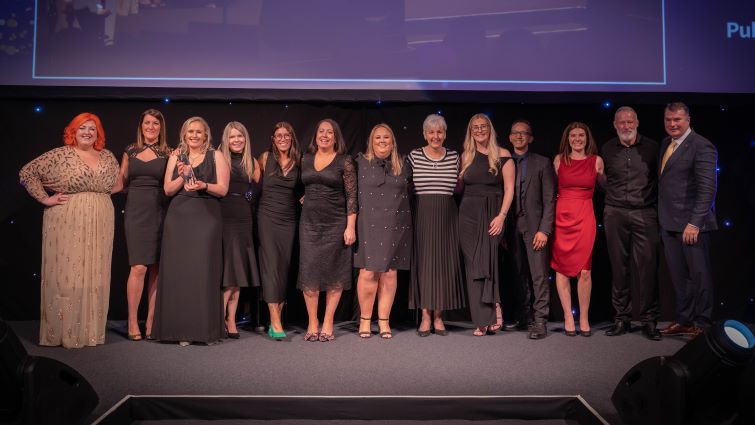 This image shows staff on stage after receiving the COSLA Excellence Awards 2025 in the Tackling Inequalities and Improving Health category