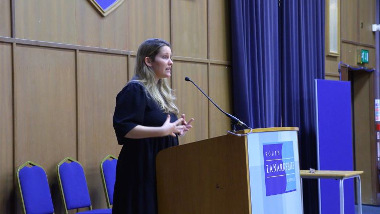 This image shows Laura Bates speaking to a conference on gender based violence hosted by South Lanarkshire Council