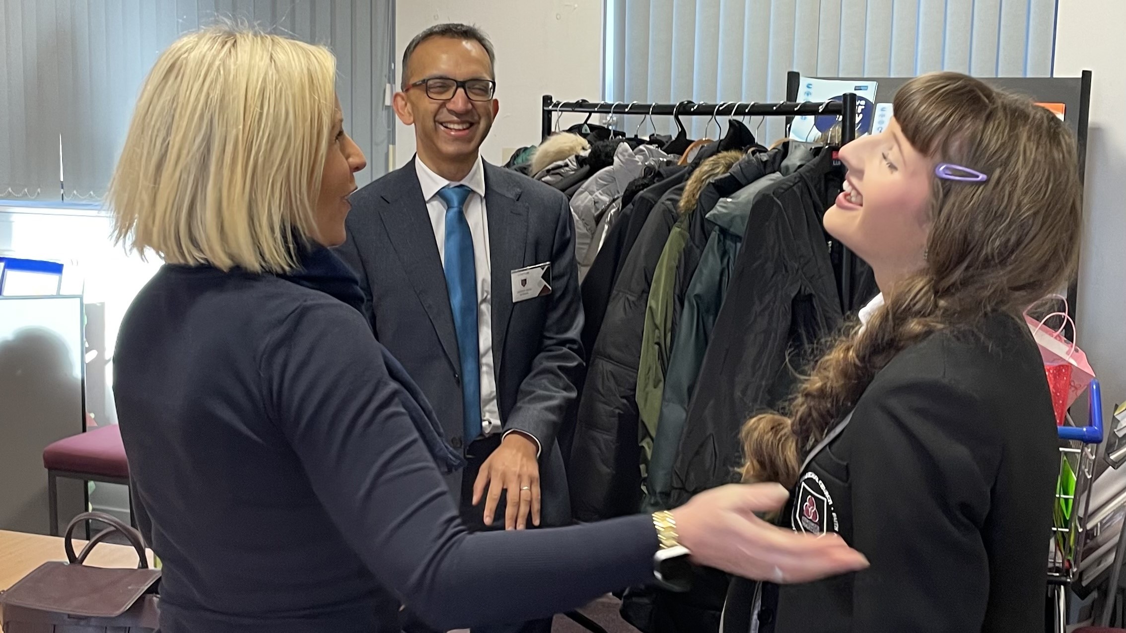 pupil and staff inside Trinity High School discussing success of winter jackets appeal